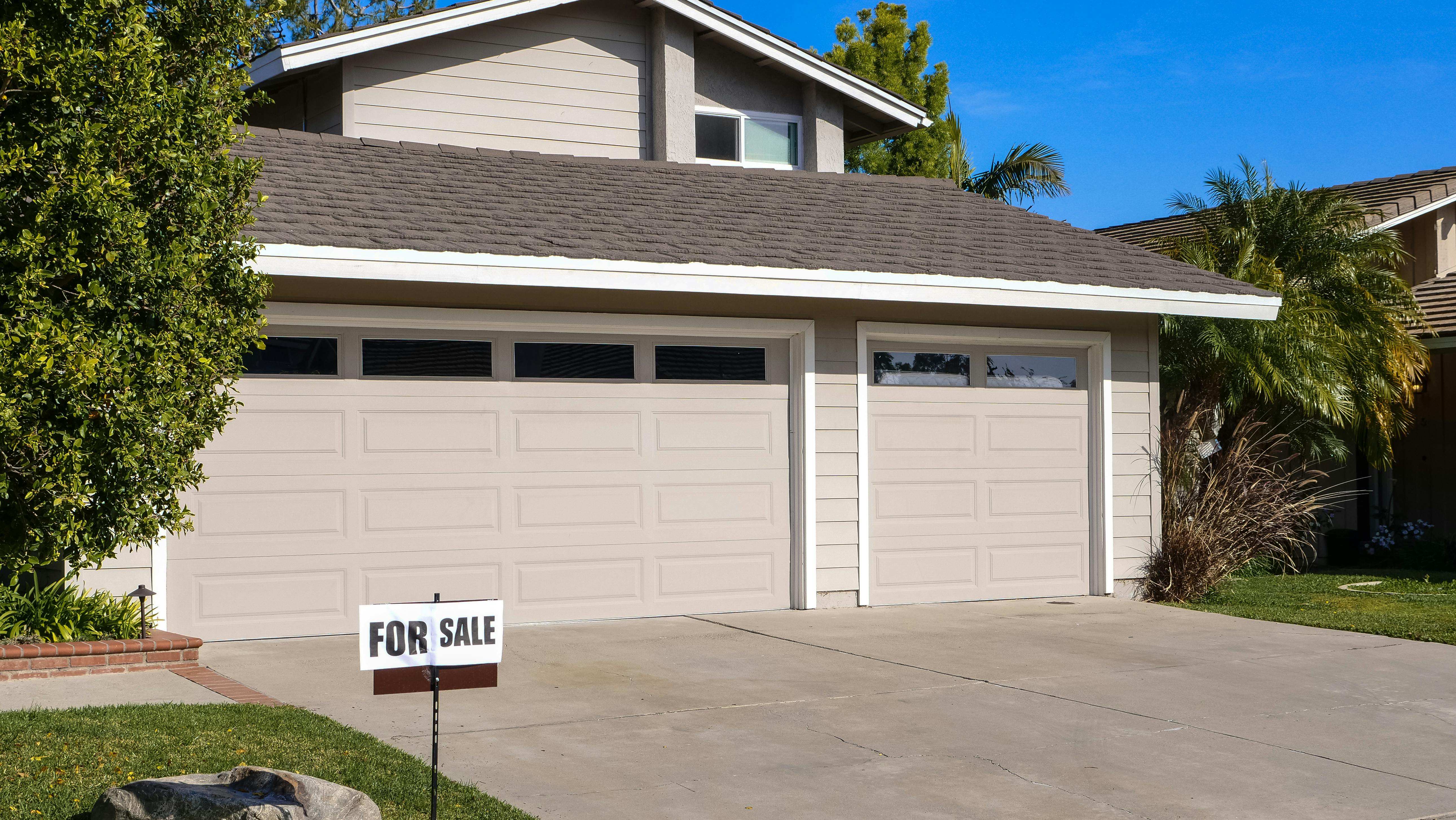 Contemporary home with a for sale sign in the front yard